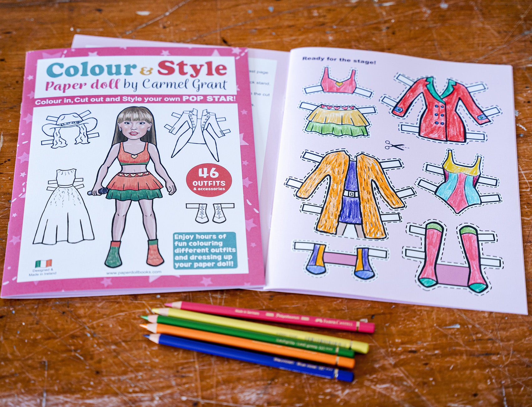 Popstar paper doll cut out coloring book and pencils on a wooden surface