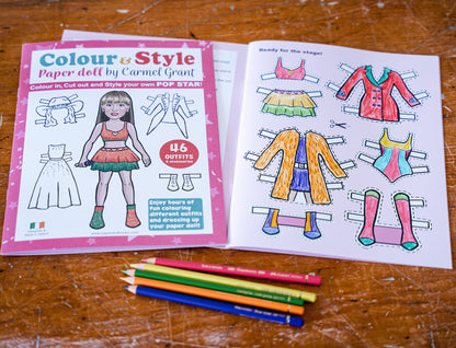 Popstar paper doll cut out coloring book and pencils on a wooden surface